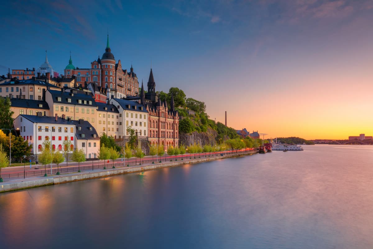 Luxury travel Stockholm — premium chauffeur car parked beside a Stockholm waterfront in evening light